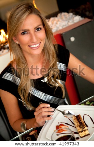 beautiful woman enjoying a delicious dessert at a fancy restaurant