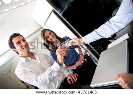 Happy customers paying at the hotel with a credit card