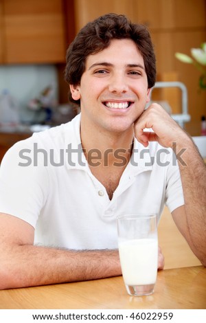 Handsome man with a glass of milk indoors