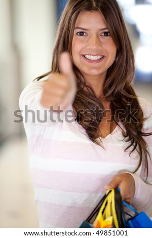 Beautiful shopping woman with thumbs up and smiling