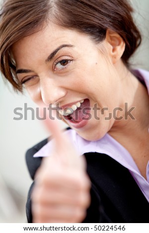 Excited business woman with thumbs up at the office