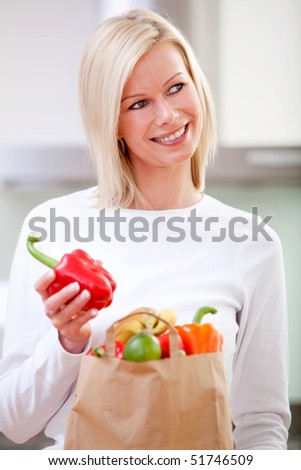 Beautiful woman with a shopping bag full of fruits and vegetables
