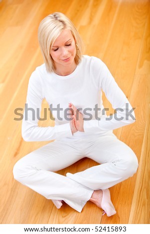 Young woman practicing yoga at home with eyes closed