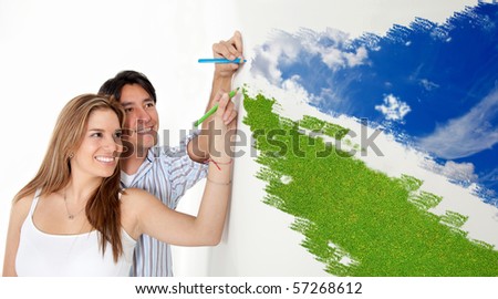 Happy couple drawing a landscape with blue sky and green grass