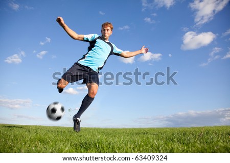 Handsome male football player kicking the ball