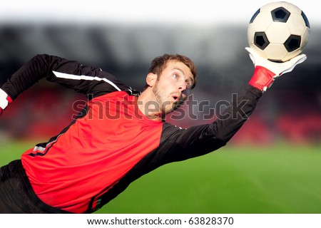 Football goalkeeper at a stadium catching the ball