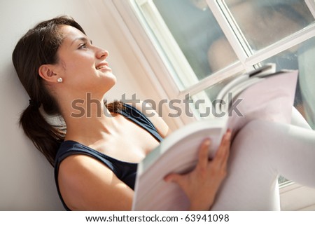 Woman studying at home and looking through the window