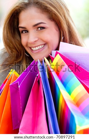 Happy shopping woman with bags and smiling