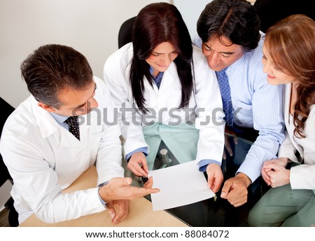 Business people negotiating medical insurance with a group of doctors