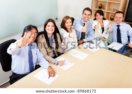 Successful business team in a meeting with thumbs up