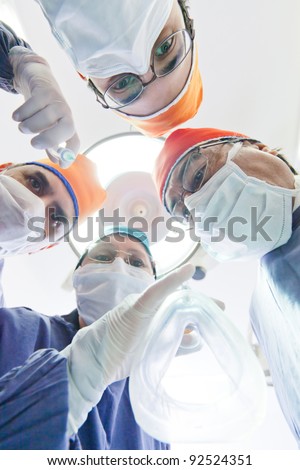 Group of surgeons in an operating room putting a breathing mask