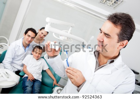 Dentist explaining how to brush teeth on a prosthesis