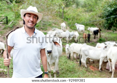 Male rancher in a farm with cattle at the background