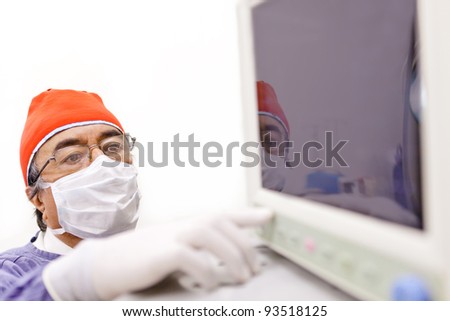 Doctor checking vital signs in a monitor at the surgery room