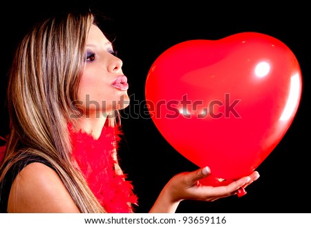 Woman celebrating Valentines Day kissing a heart shaped balloon