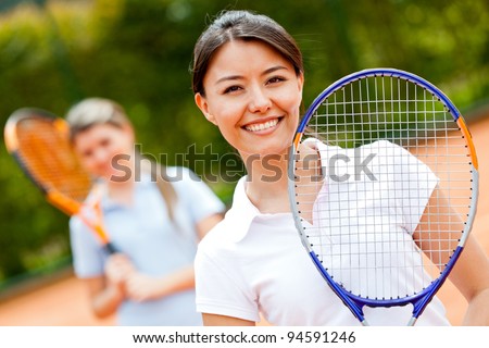 Female tennis player at the court playing doubles