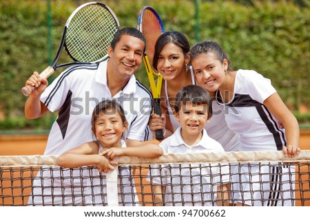 Happy family playing tennis and holding rackets