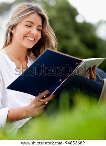 Beautiful woman with a notebook studying at the park