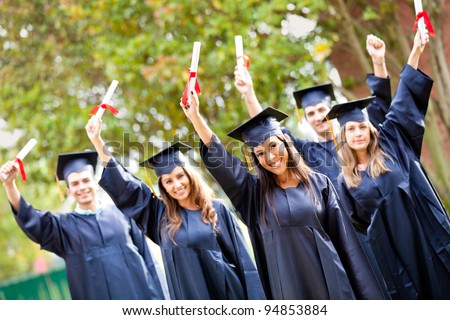Happy group of students with arms up at their graduation
