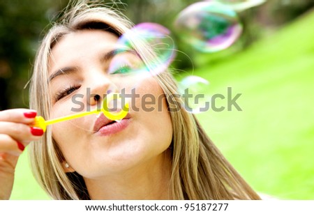 Woman blowing soap bubbles with a wand at the park