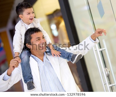 Father and son window shopping at the mall looking happy