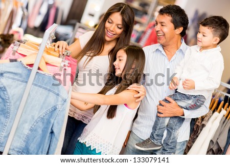 Family shopping for clothes and looking happy