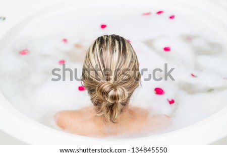 Back of blonde woman taking a foam bath