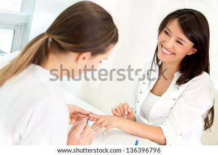 Happy woman getting her nails done at the beauty salon