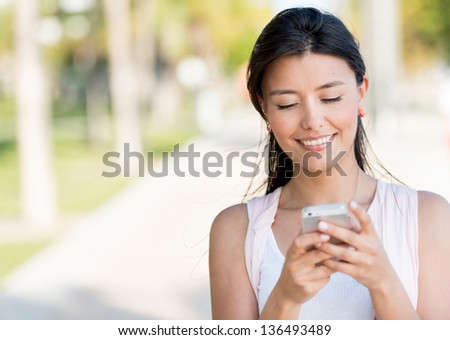 Portrait of a woman sending text message from her phone