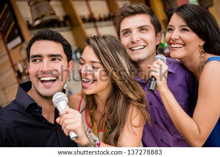Group of people karaoke singing at a bar having fun