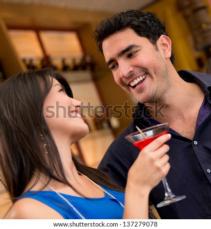 Couple having drinks at a club and smiling