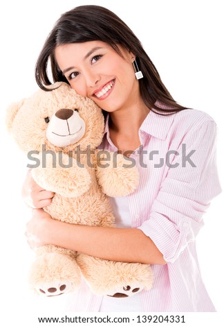 Sweet woman hugging a teddy bear and smiling - isolated over white