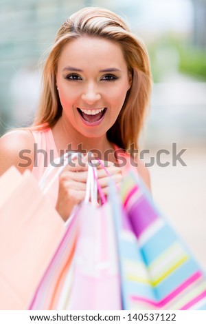 Female shopper looking very happy holding bags