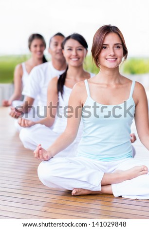 Group of calm people doing yoga and looking peaceful