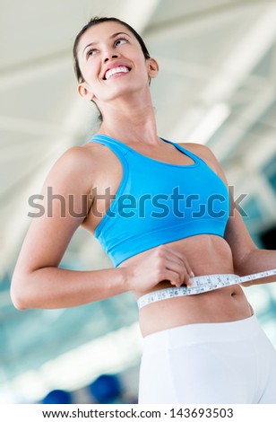 Gym woman taking measurements controlling her weight loss