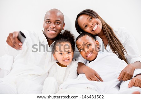 Beautiful family in bed watching tv and looking very happy