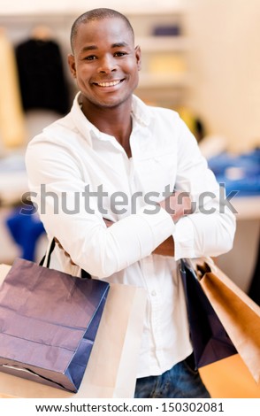 Happy shopping man holding bag at the mall and smiling