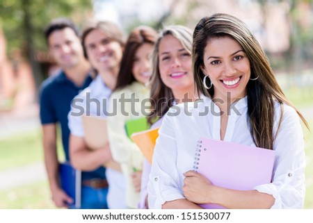 Happy group of students holding notebooks and smiling outdoors