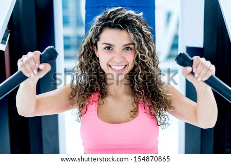 Happy woman working out at the gym in a machine