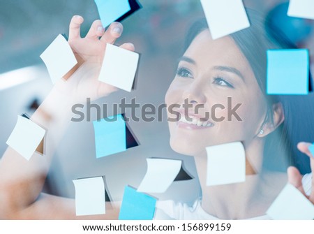 Happy woman multitasking with post-its all over the place