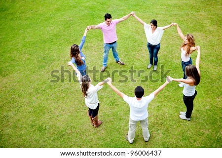 Group of people in a circle holding hands - outdoors