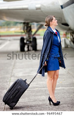 Beautiful air hostess with her bag next to an airplane - Stock Image -  Everypixel