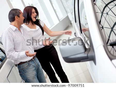 Loving couple at the dealership buying a car