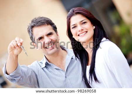 Happy couple holding the key to their new house