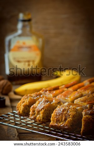 The banana cake with walnuts and maple syrup cut with slices on a wooden table. Selective focus. Style rustic.