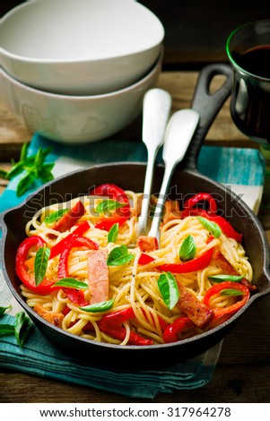 spaghetti with pepper and ham in a frying pan. Top view.rustic style.selective focus