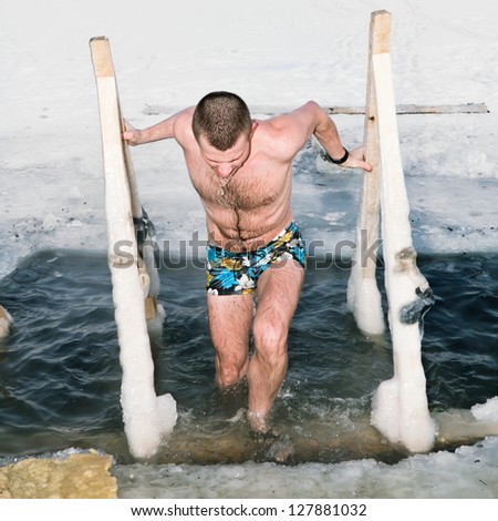 A man diving in the ice-hole on the Lake in winter