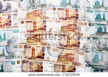 SOAP bubbles against a backdrop of banknotes in five and one thousand rubles