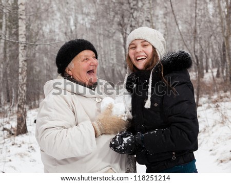 Senior  woman and girl  play snowballs