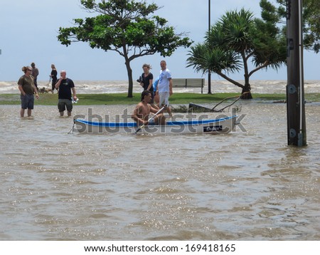 BRISBANE, QLD, AUSTRALIA - January 27: A man rows past in a canoe as locals explore the flooded streets of Sandgate during the storm surge floods of 27 January 2013
